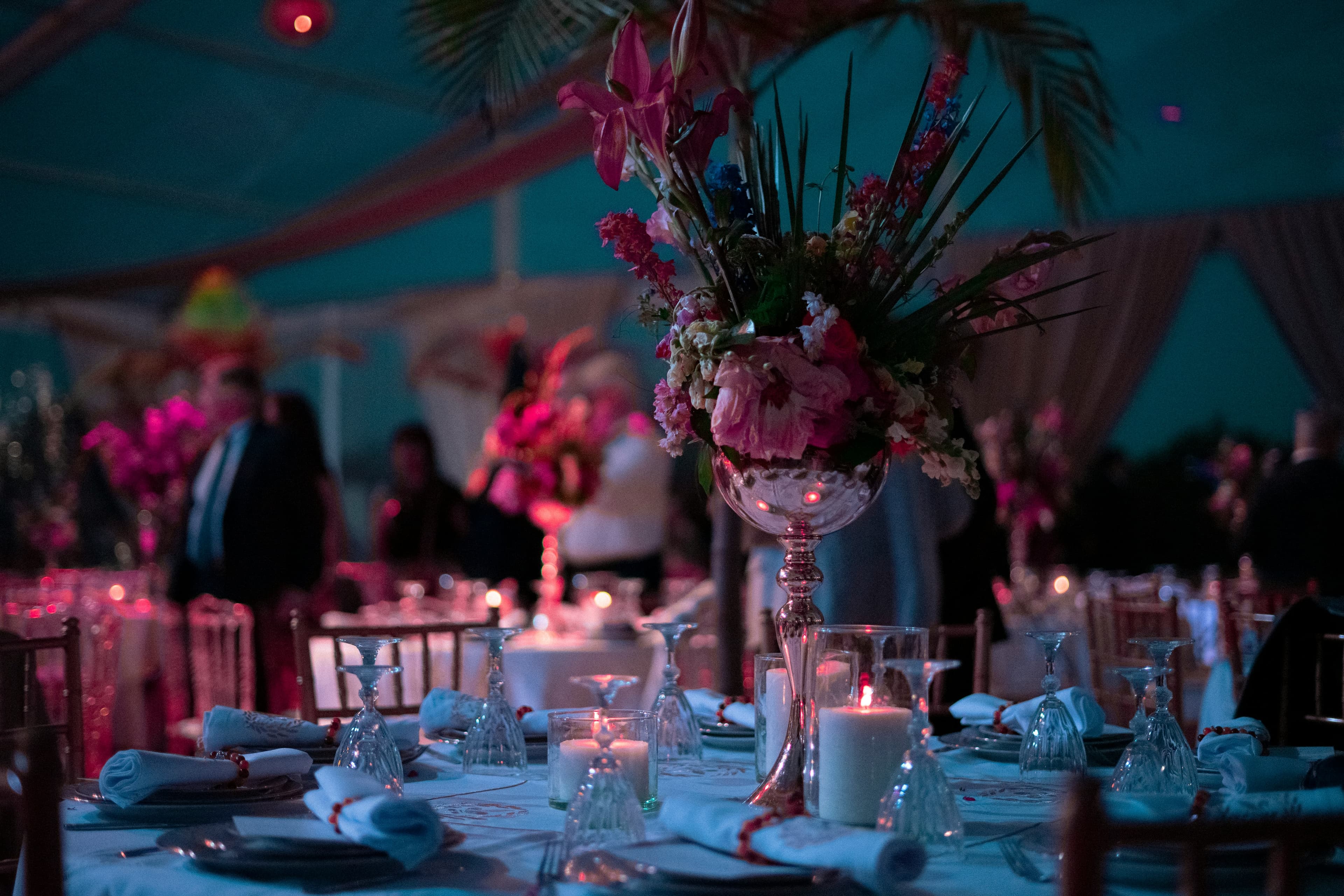 Candlelit event table with a tall pink floral centerpiece