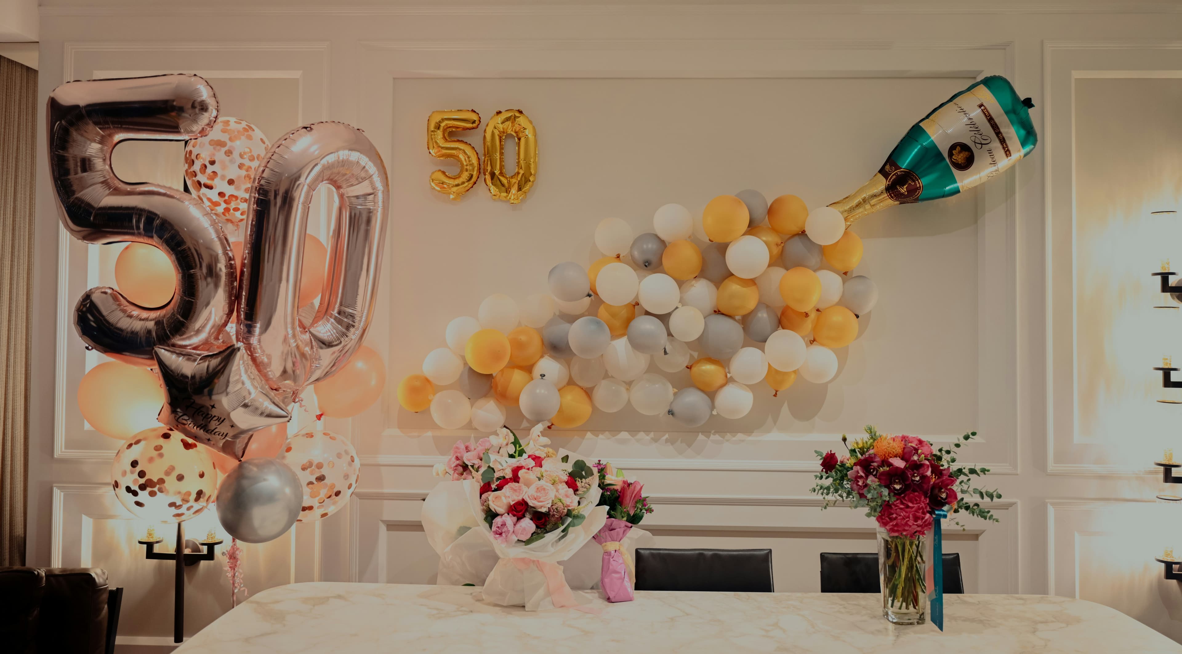 Fiftieth birthday display with balloons and flower arrangements